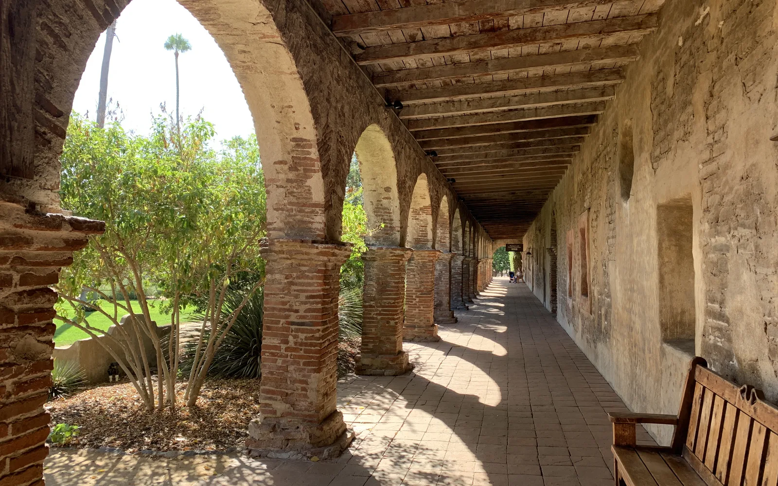 Shaded arcade columns and walkway with arches at the mission showing historic Spanish colonial architecture